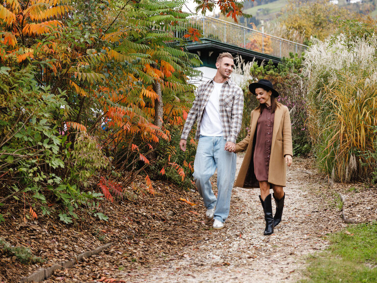 Paar spaziert durch den herbstlichen Romantikgarten