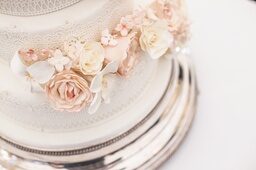 weiße Hochzeitstorte mit zartrosa Blumen