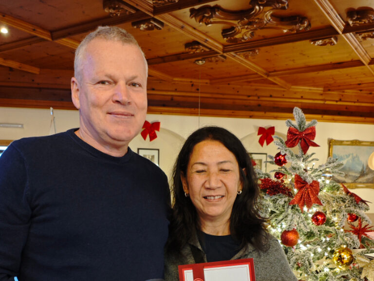 Paar posiert mit Urkunde anlässlich Gästeehrung