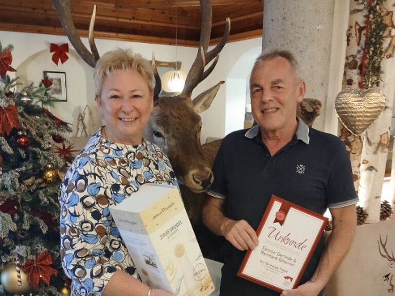 Paar posiert mit Urkunde anlässlich Gästeehrung