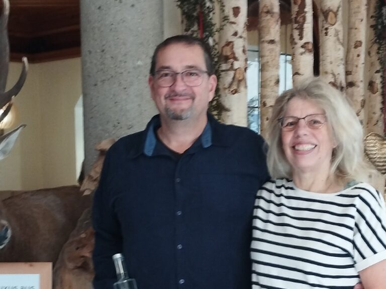 Aufgrund des Geburtstages des Mannes posiert ein Paar mit Geschenk vom Hotel