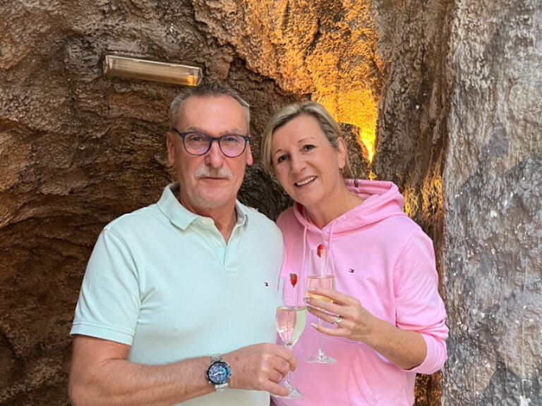 Paar posiert mit Sektglas anlässlich Geburtstag