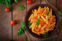 Penne mit Tomatensauce und Basilikum verziert