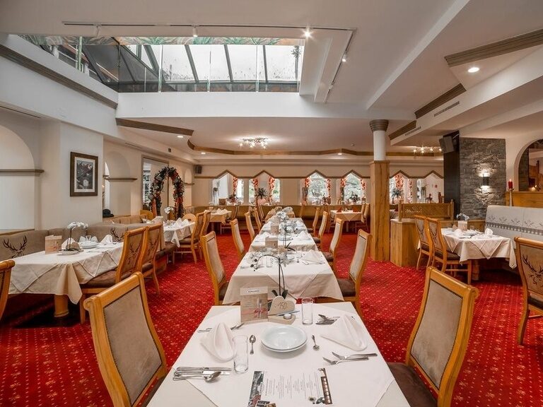 Teil des Restaurants mit rotem Teppich und gedeckten Tischen