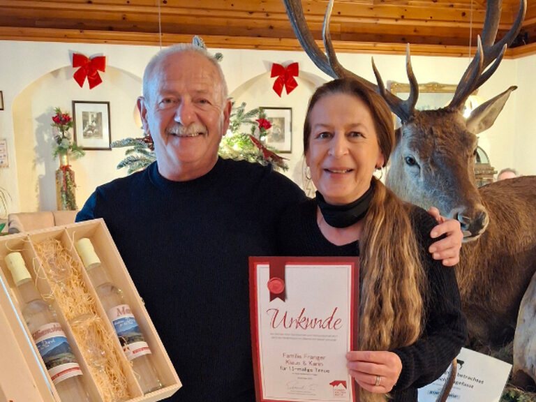 Paar posiert mit Urkunde anlässlich Gästeehrung
