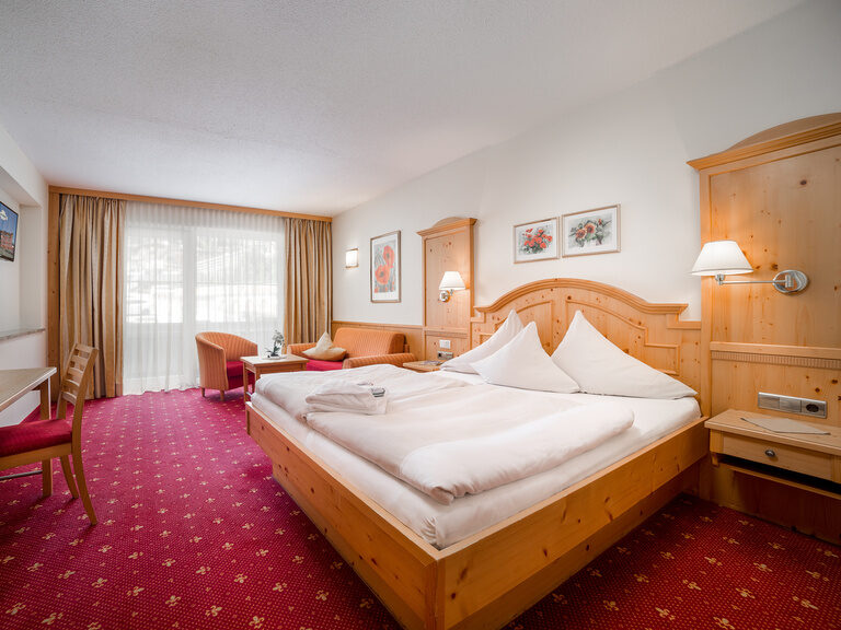 Standard Doppelzimmer mit rotem Teppich und Sitzecke