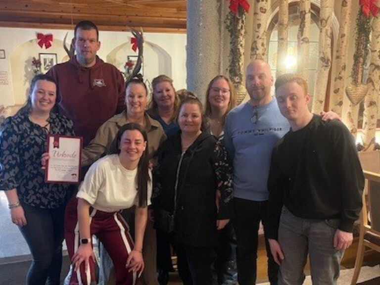 Familie posiert anlässlich Gästeehrung mit Urkunde und Geschenk