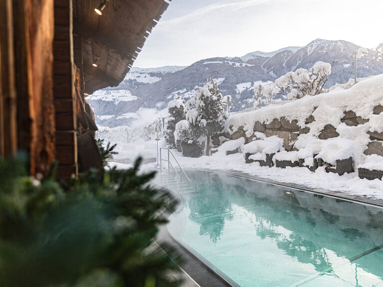 Beheizter und dampfender Außenpool mit Blick auf die verschneiten Berge